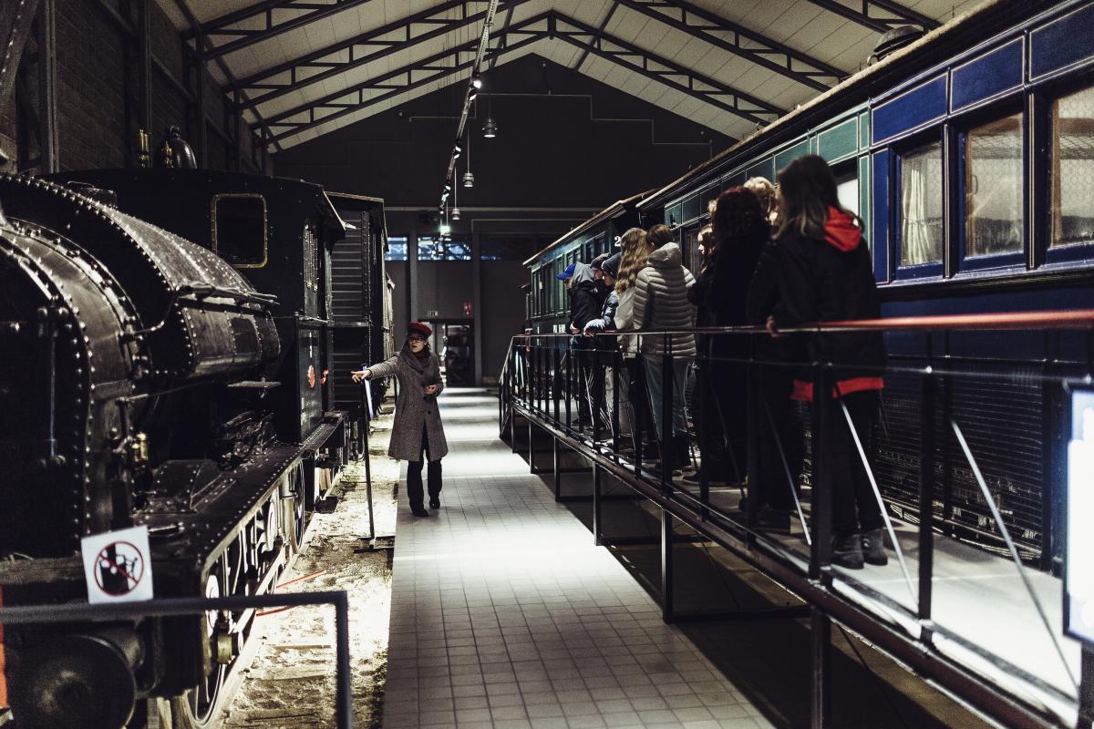 Opas esittelee Suomen vanhinta säilynyttä höyryveturia koululaisille opastuskierroksella Suomen Rautatiemuseon näyttelyhallissa.