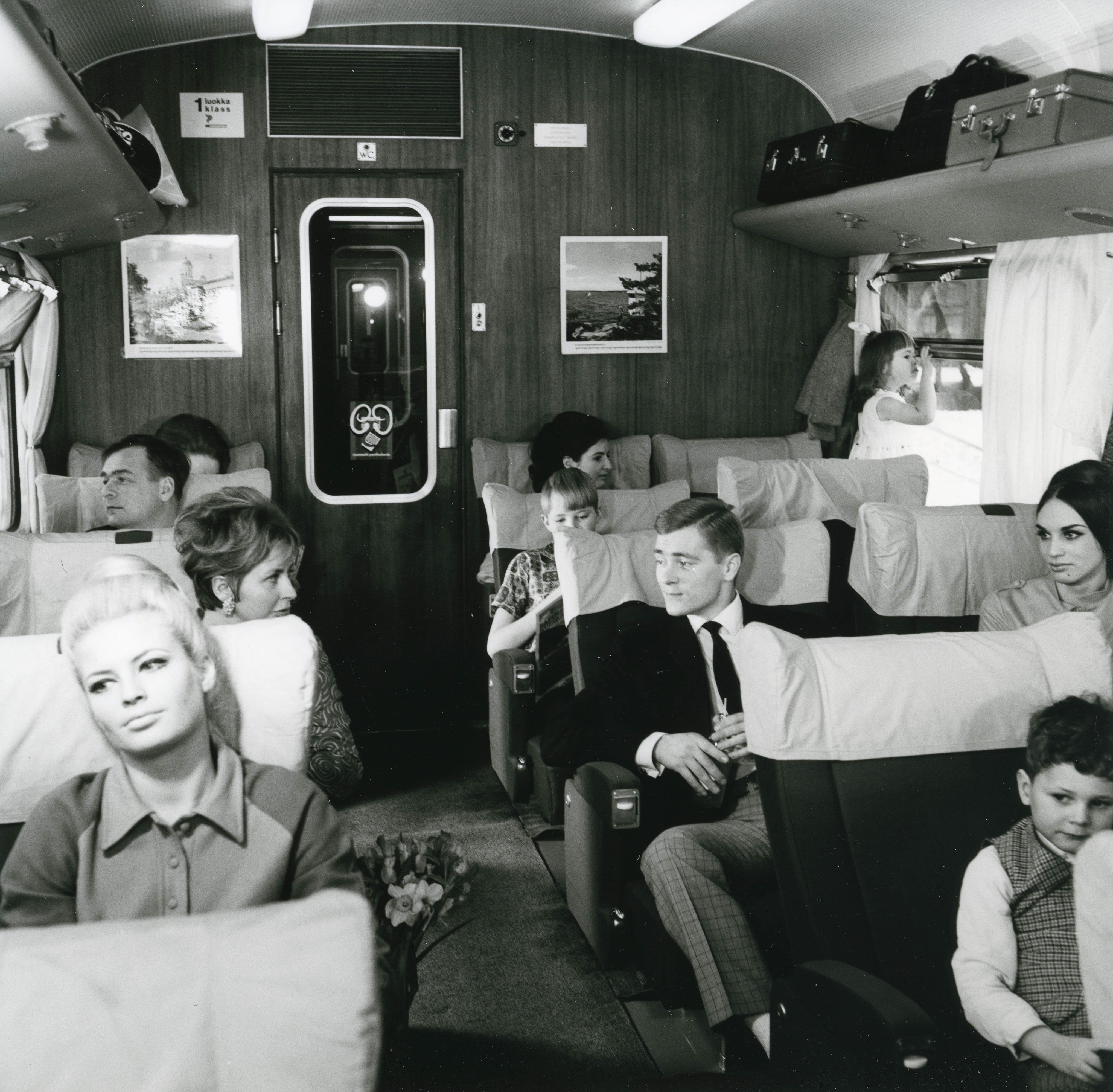 Eri-ikäisiä matkustajia istumassa Porkkana-junan vaunussa vuonna 1968.