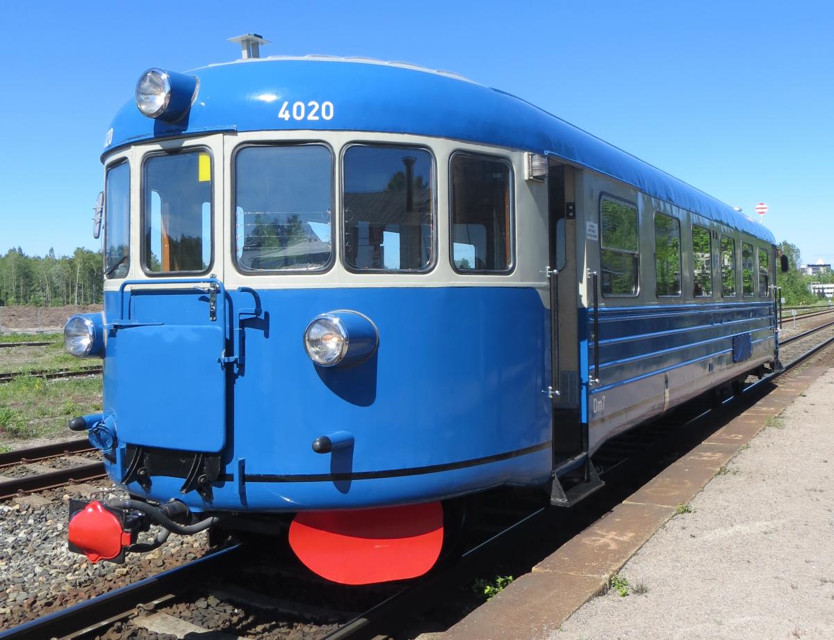 Sinivalkoinen Lättähattu-moottorivaunu on liikenteessä museon ratapihalla. 