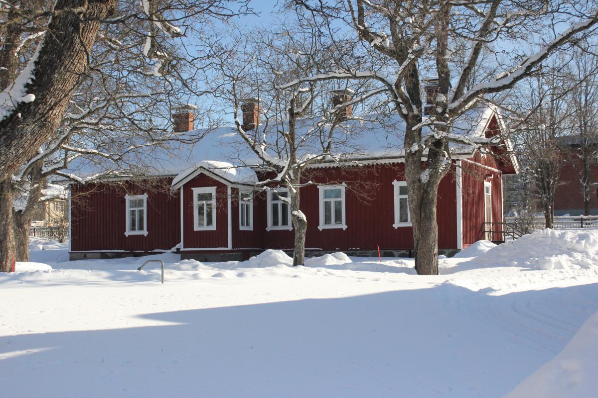 Kasarmi Rautatiemuseon puistossa on lumipeitteen ja puiden ympäröimänä.