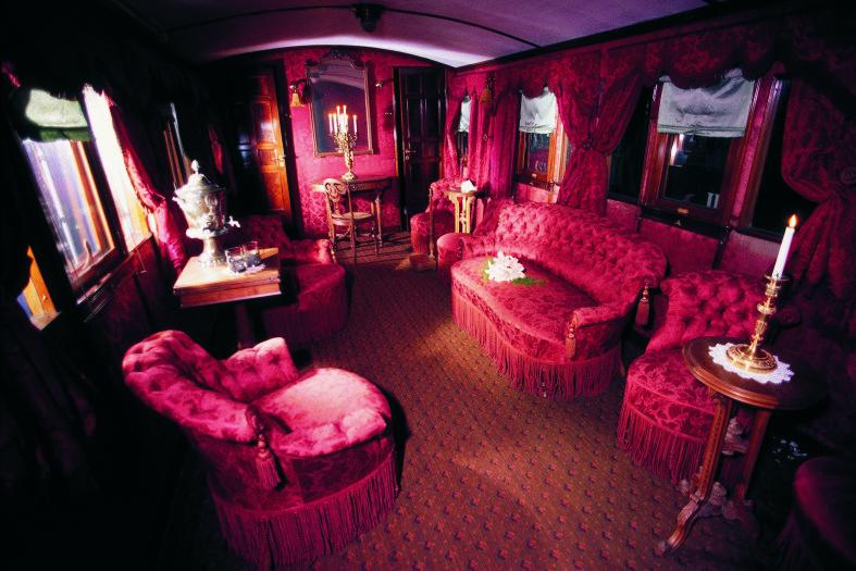 Punaisella silkillä verhoiltuja huonekaluja keisarillisen junan salonkivaunussa